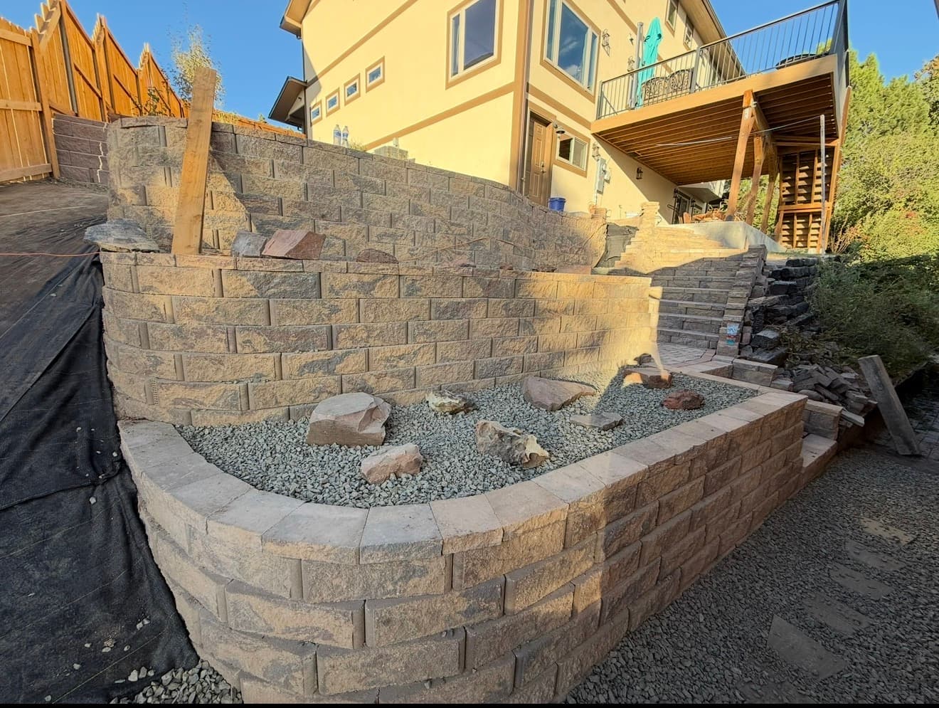 Cheyenne retaining wall: multi-tier masonry wall with stairs and gravel planter beds